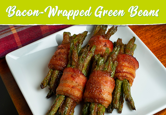 bacon-wrapped green beans on a white rectangular plate